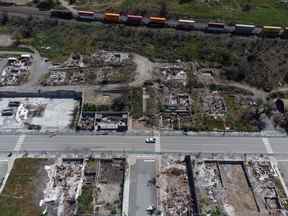 Un train de marchandises passe devant les restes de maisons et d'entreprises détruites par l'incendie de 2021, à Lytton, en Colombie-Britannique, le mercredi 15 juin 2022. Le chef par intérim de la Première Nation de Lytton a déclaré qu'une trentaine de personnes évacuées étaient brièvement rentrées chez elles dans le but de sauver de la nourriture qu'ils ont laissée dans des congélateurs lorsqu'un incendie de forêt s'est déclaré jeudi à près de deux kilomètres au nord-ouest de Lytton. PRESSE CANADIENNE/Darryl Dyck