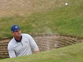 Le golfeur américain Bryson DeChambeau joue depuis le bunker du trou de la route lors d'un tour d'entraînement pour le 150e British Open Golf Championship sur le Old Course à St Andrews en Écosse le 13 juillet 2022.