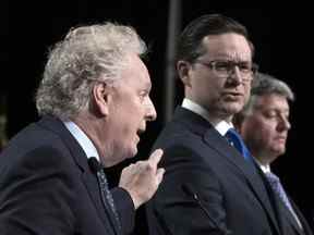 Jean Charest, à gauche, et Pierre Poilievre, au milieu, s'affrontent lors d'un débat des candidats à la direction du Parti conservateur à Ottawa, le 5 mai 2022.