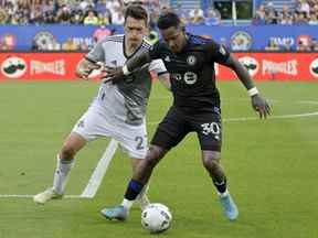 Le milieu de terrain du CF Montréal Romell Quioto (30 ans) a résisté au défenseur du Toronto FC Shane O'Neill lors de la première mi-temps au Stade Saputo samedi soir.