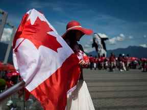 Summer Shen agite un drapeau canadien tout en arborant une tenue patriotique lors des célébrations de la fête du Canada à Vancouver, le 1er juillet 2019.