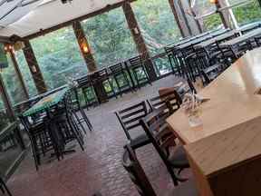 Restaurant avec tables et chaises vides installées.