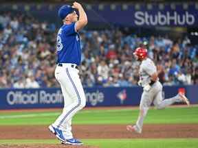 Le lanceur de relève des Blue Jays de Toronto, Trevor Richards, se prépare pour son prochain lancer alors que le joueur de premier but des Cardinals de St. Louis, Albert Pujols, fait le tour des buts après avoir réussi un circuit de trois points en cinquième manche au Rogers Centre de Toronto, le 27 juillet 2022.