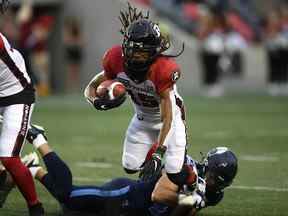 Le receveur large des Redblacks d'Ottawa Ryan Davis (15 ans) tente d'échapper au tacle du secondeur des Argonauts de Toronto Trevor Hoyte (43 ans) pendant la première moitié de l'action de football de pré-saison de la LCF à Ottawa le vendredi 27 mai 2022.