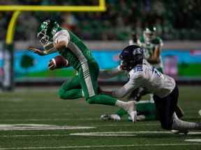 Le quart-arrière des Roughriders de la Saskatchewan Cody Fajardo (7) est attaqué par le demi défensif des Argonauts de Toronto Jamal Peters (12) lors d'un match de football de la LCF au stade Mosaic de Regina, en Saskatchewan, le 17 septembre 2021. BRANDON HARDER/ Regina Leader-Post