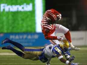 Les Stampeders de Calgary William Langlais est plaqué par les Blue Bombers de Winnipeg DeAundre Alford lors d'une action de la LCF au stade McMahon de Calgary le samedi 20 novembre 2021.