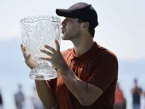 L'ancien quart-arrière de la NFL, Tony Romo, embrasse le trophée après avoir remporté le championnat américain du siècle au parcours de golf Edgewood Tahoe le 10 juillet 2022 à Stateline, Nevada.