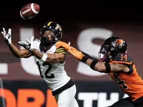 Tim White (12 ans) des Tiger-Cats de Hamilton ne réussit pas la réception dans la zone des buts lors d'une tentative de conversion de deux points alors que Marcus Sayles (14 ans) des Lions de la Colombie-Britannique défend pendant la seconde moitié du match de football de la LCF à Vancouver, jeudi, 21 juillet 2022.