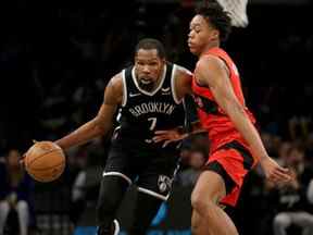 L'attaquant des Brooklyn Nets Kevin Durant (7) contrôle le ballon contre l'attaquant des Raptors de Toronto Scottie Barnes (4) au cours du quatrième quart-temps au Barclays Center en décembre 2021.