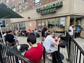 Les gens se pressent autour d'un café Starbucks pour utiliser son wifi gratuit sur le réseau Bell, lors d'une panne majeure des réseaux mobiles et Internet de Rogers Communications à Toronto, le 8 juillet 2022.