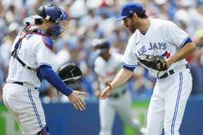 Danny Jansen (à gauche) et Jordan Romano des Blue Jays célèbrent après que les Jas aient vaincu les Tigers de Detroit au Rogers Centre le dimanche 31 juillet 2022 à Toronto.  COLE BURSTON/GETTY IMAGES