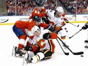 Le centre des Flames de Calgary Dillon Dube (29 ans) et le défenseur des Panthers de la Floride MacKenzie Weegar (52 ans) se battent pour une rondelle libre au cours de la première période au BB&T Center.