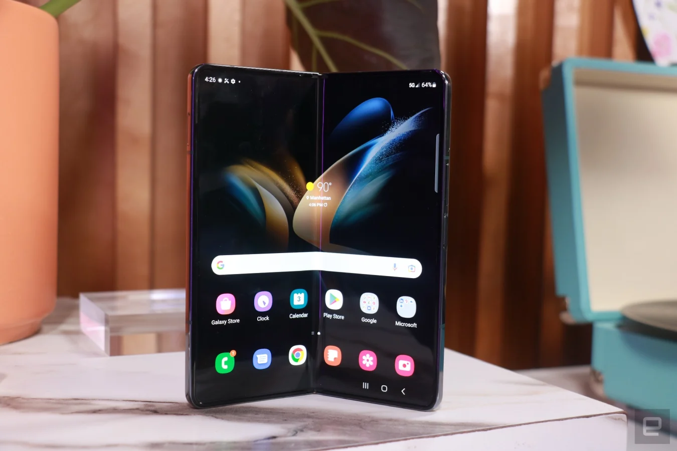 Un Galaxy Z Fold 4 déplié un peu plus de la moitié, avec son écran interne tourné vers l'extérieur.