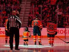 Le patineur de cinq ans de la Banque Scotia Ben Stelter se tient aux côtés des Oilers d'Edmonton et des Sharks de San Jose pendant les hymnes nationaux lors d'un match de la LNH à Rogers Place à Edmonton le 24 mars 2022.