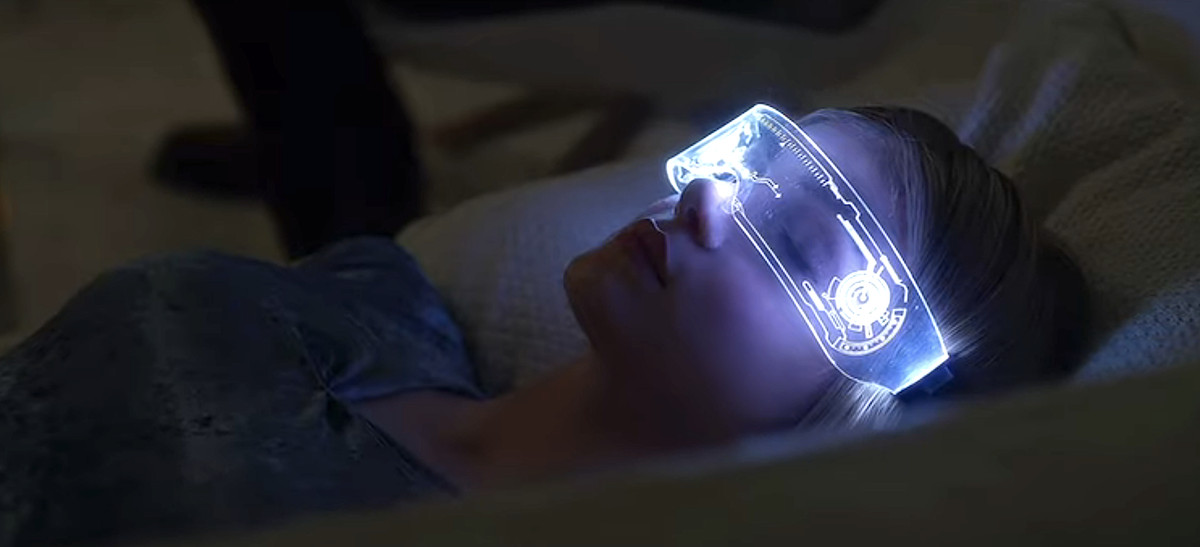 Elena Kampouris est allongée dans son lit avec des lunettes AR lumineuses dans Wifelike