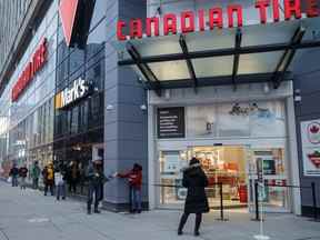 Des clients font la queue pour un ramassage en bordure de rue dans un magasin Canadian Tire Corp. à Toronto.