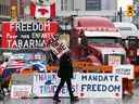 Un manifestant marche devant des camions stationnés alors que des manifestants protestent contre les restrictions liées au COVID-19, à Ottawa le 8 février 2022.