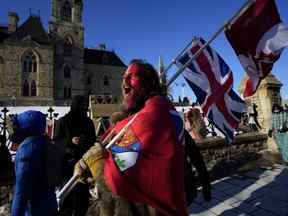 Un manifestant crie «liberté» à une personne qui a tenté de coller une pancarte en papier sur un camion critiquant le soi-disant «convoi de la liberté», une manifestation contre les mesures COVID-19 qui s'est transformée en une manifestation antigouvernementale plus large, le 18e jour , à Ottawa, le 14 février 2022.