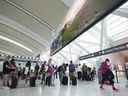 Les gens font la queue avant d'entrer dans la sécurité à l'aéroport international Pearson de Toronto le vendredi 5 août 2022.