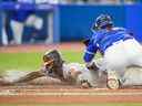 Jorge Mateo des Orioles de Baltimore glisse sous l'étiquette de Danny Jansen des Blue Jays de Toronto au Rogers Centre le 15 août 2022 à Toronto. 