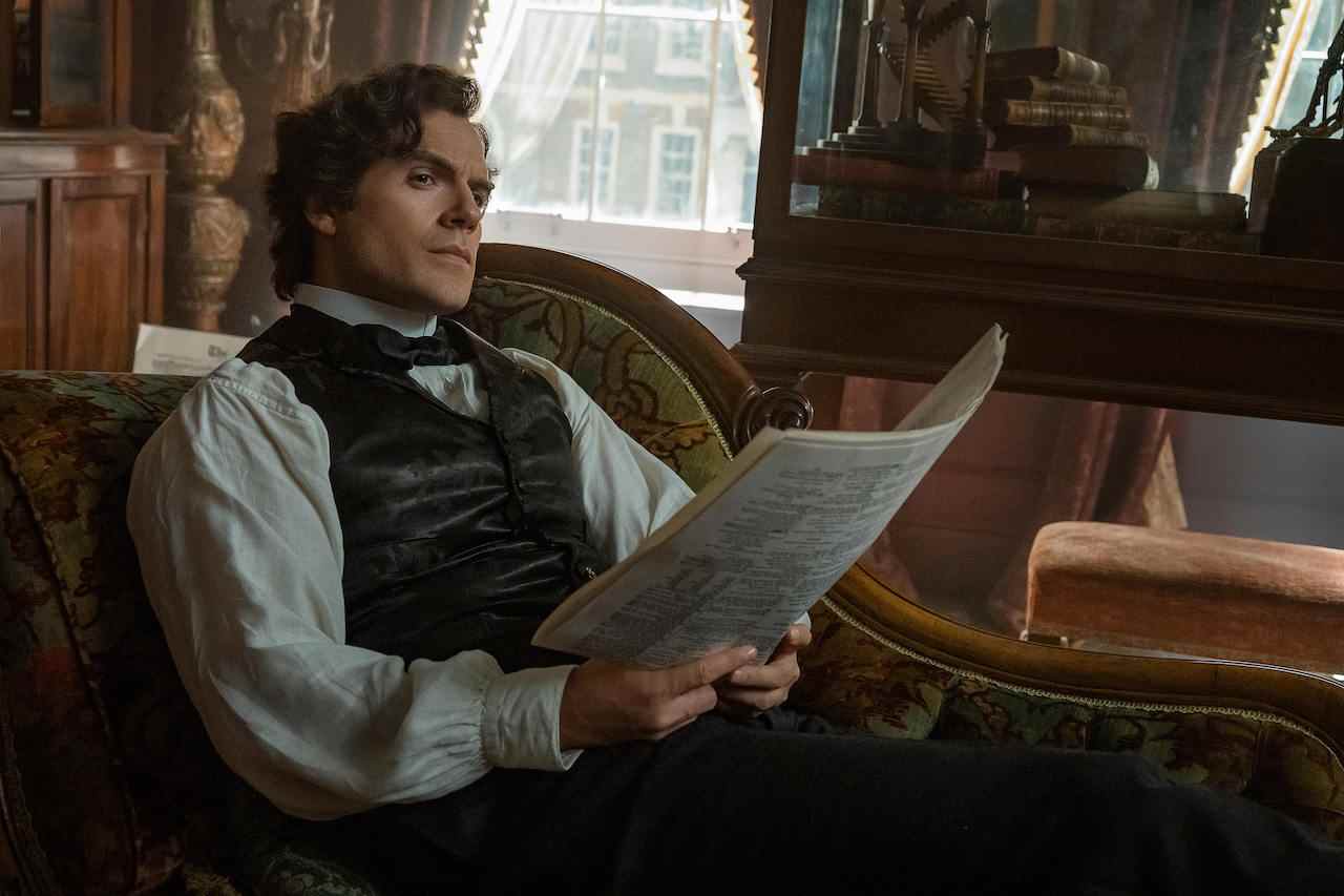 Sherlock Holmes d'Henry Cavill levant les yeux après avoir lu le journal dans Enola Holmes 2