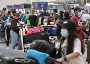 Les voyageurs font la queue au terminal 1 de l'aéroport international Pearson de Toronto alors que les retards se poursuivent, le jeudi 7 juillet 2022.