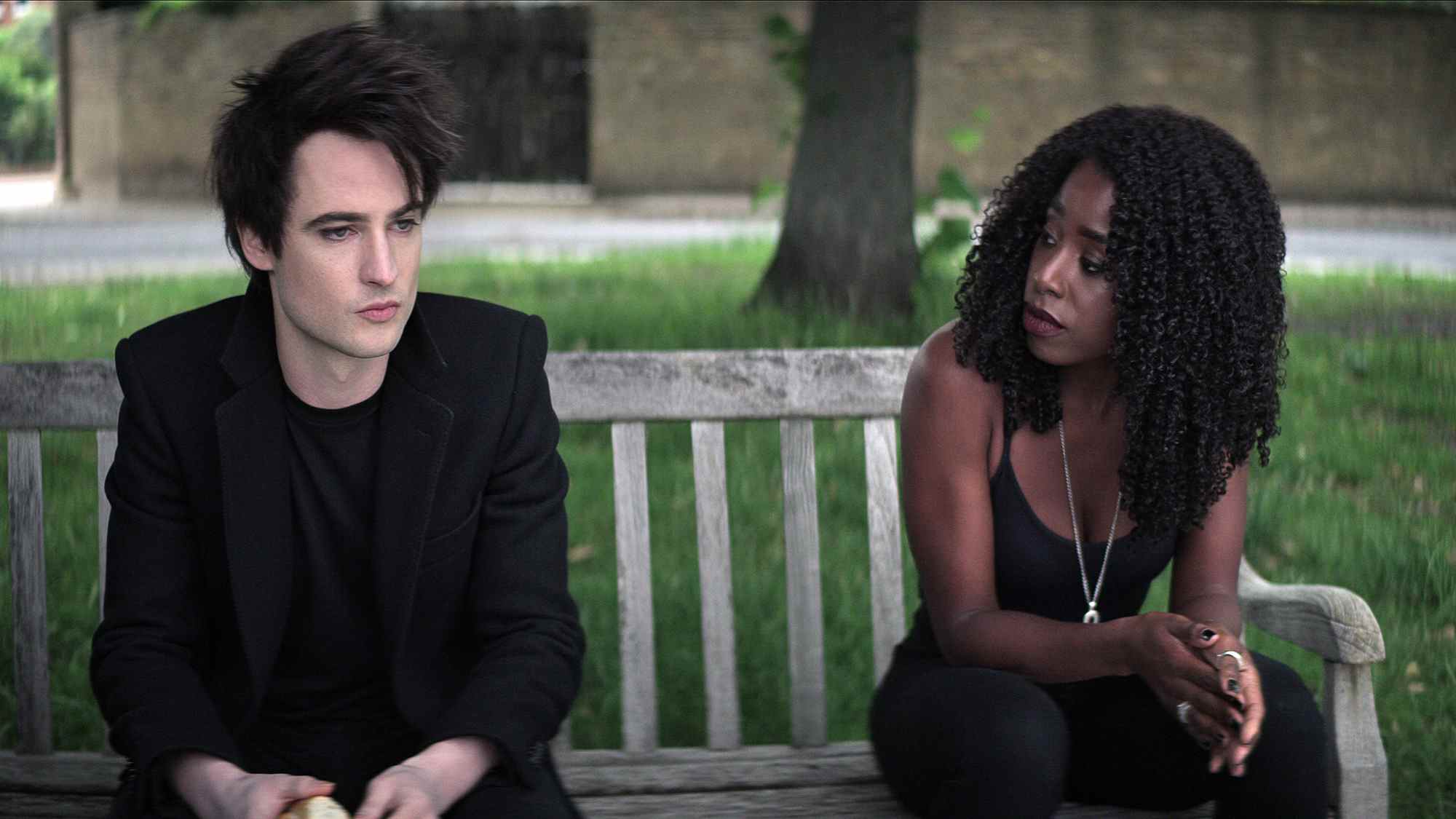 (De gauche à droite) Tom Sturridge comme Dream, Kirby Howell-Baptiste comme Death, sur un banc, dans The Sandman