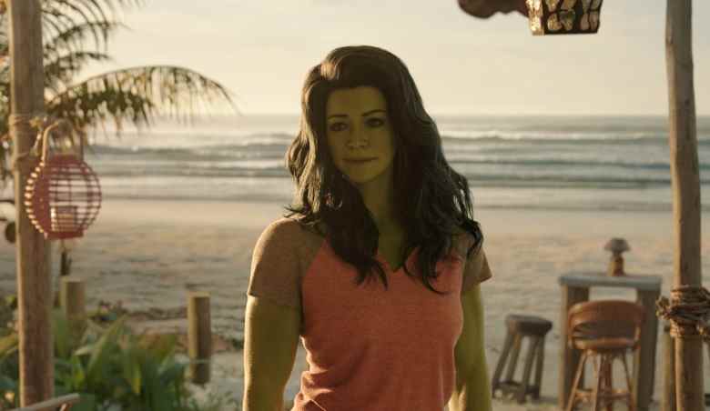 A tall woman with wavy black hair and green skin standing on a beach; still from "She-Hulk: Attorney at Law"