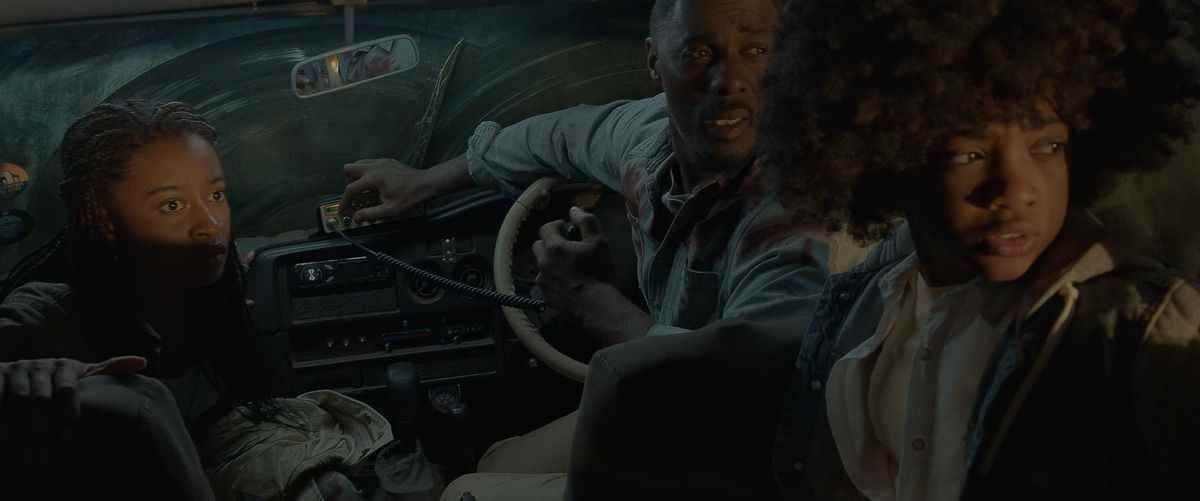 Idris Elba, Iyana Halley et Leah Jeffries ont l'air effrayés dans une voiture la nuit dans Beast