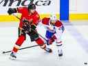 Sean Monahan (23 ans) des Flames et le défenseur des Canadiens Jeff Petry se battent pour la rondelle lors de la première période au Scotiabank Saddledome de Calgary le 24 avril 2021. 