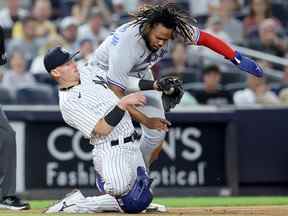 Le joueur de premier but des Blue Jays Vladimir Guerrero Jr. (27) glisse en toute sécurité en troisième devant le tag par le joueur de troisième but des Yankees de New York Josh Donaldson (28) au Yankee Stadium.