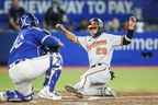 Ramon Urias des Orioles de Baltimore glisse à la maison en toute sécurité pour marquer sur un simple de Ryan McKenna contre les Blue Jays en sixième manche mardi soir au Rogers Centre.