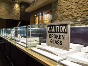 Un panneau d'avertissement sur le verre brisé après un vol récent à White Carat Co. dans le centre commercial Erin Mills Town Centre à Mississauga.  Ernest Doroszuk/Toronto Sun/Postmedia