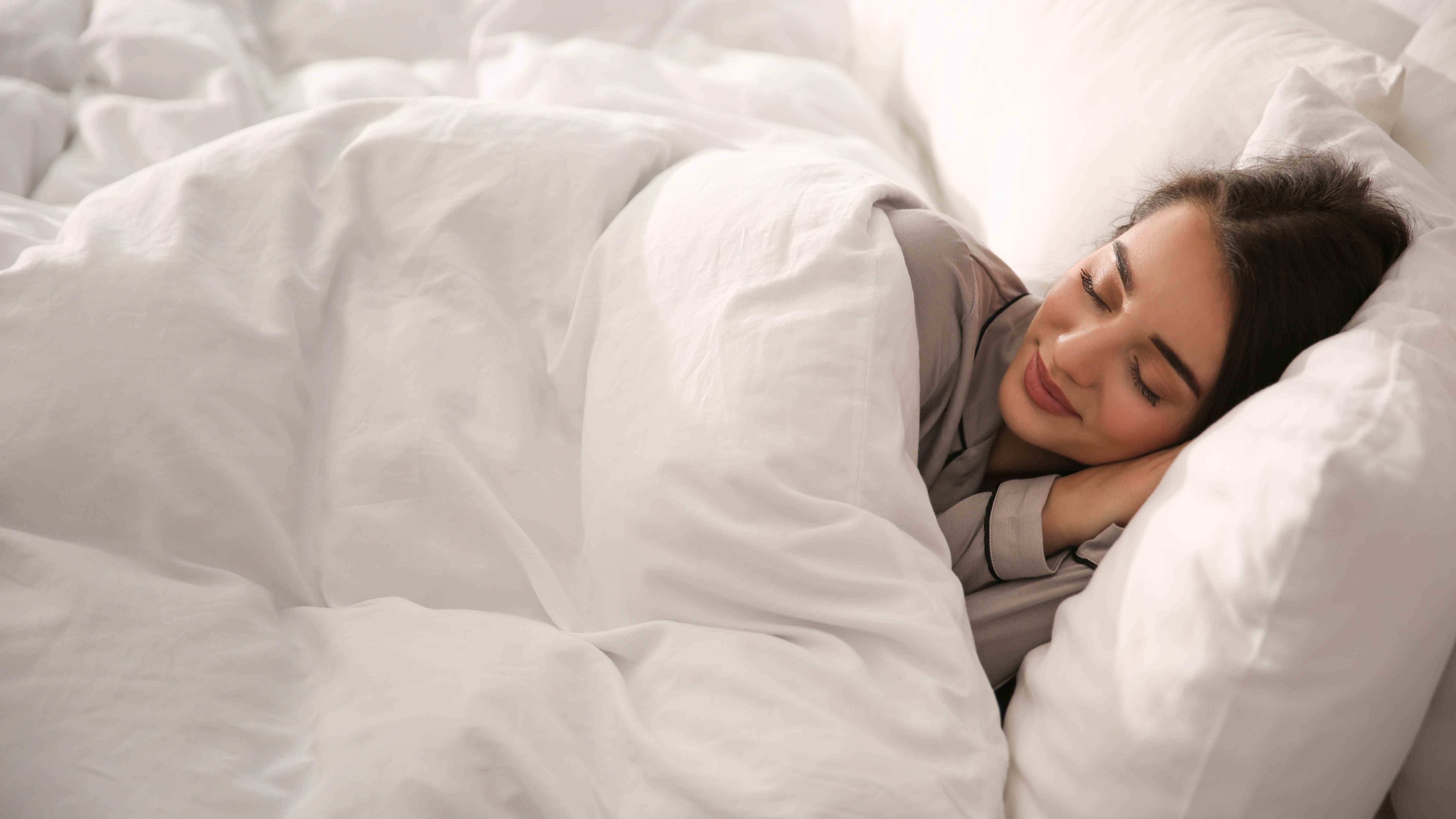 Une femme qui dort sous une épaisse couette