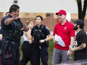 Le directeur du Peuple uni du Canada (TUPOC), William Komer (chemise rouge), s'adresse à la Police d'Ottawa devant l'ancienne église St. Brigid dans la Basse-Ville.