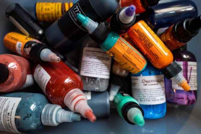 Des bouteilles d'encre de couleur mélangées dans une boîte dans un salon de tatouage à Berlin.