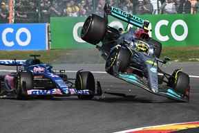 Le pilote britannique de Mercedes Lewis Hamilton, à droite, entre en collision avec le pilote espagnol d'Alpine Fernando Alonso, au centre, lors du Grand Prix de Belgique de Formule 1 sur le circuit Spa-Francophones de Spa, le 28 août 2022.