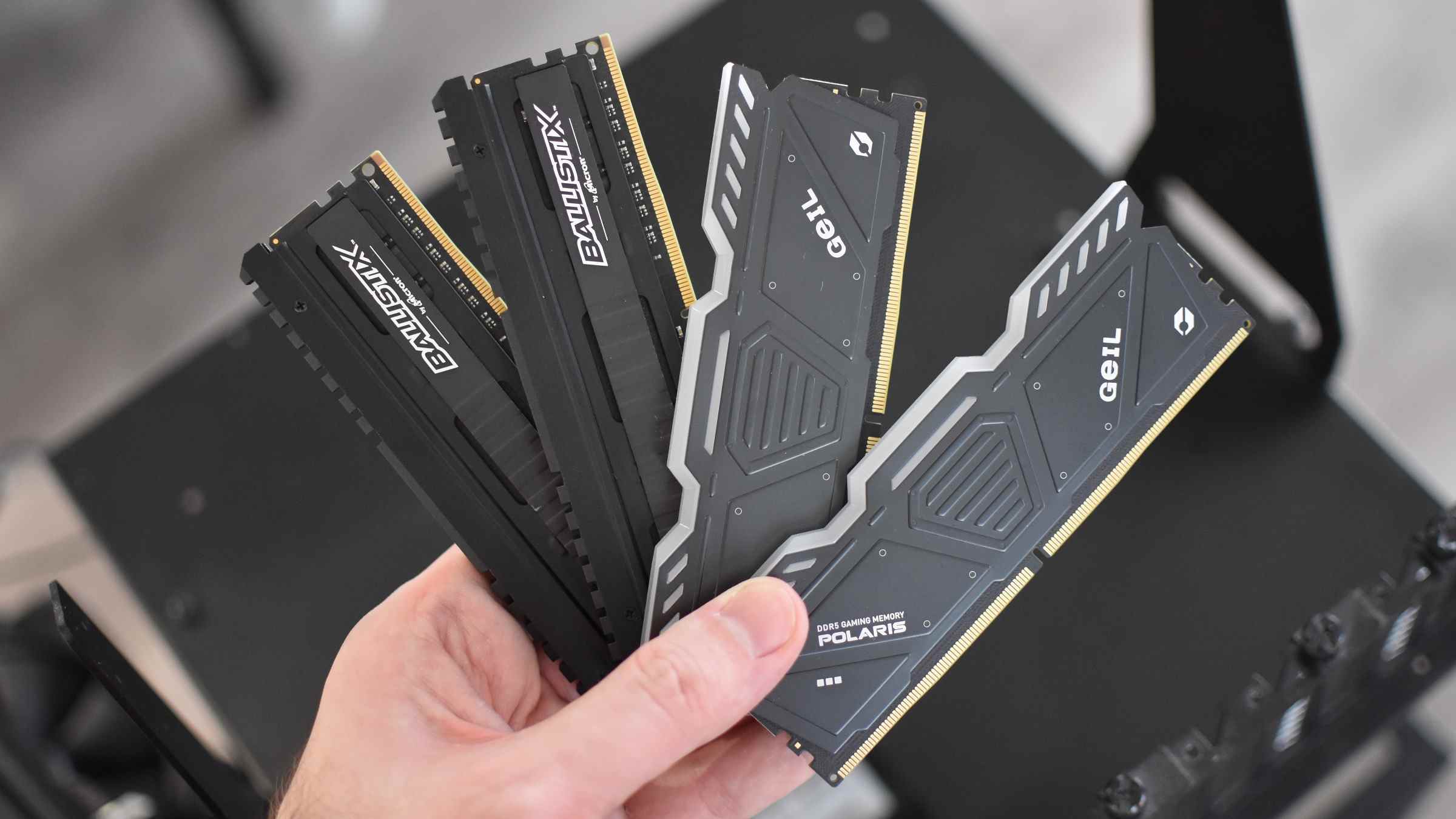 Certains modules de RAM DDR4 et DDR5, déployés et tenus dans une main.