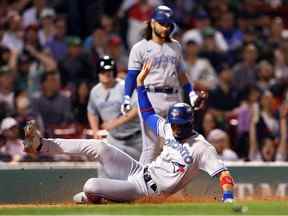 Lourdes Gurriel Jr. des Blue Jays de Toronto se glisse à domicile pour marquer contre les Red Sox de Boston lors de la troisième manche au Fenway Park le 23 août 2022 à Boston, Massachusetts.