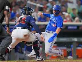 4 août 2022 ;  Minneapolis, Minnesota, États-Unis ;  Le voltigeur de centre des Blue Jays de Toronto Whit Merrifield (1) glisse à la maison contre le receveur des Twins du Minnesota Gary Sanchez (24) en huitième manche au Target Field.