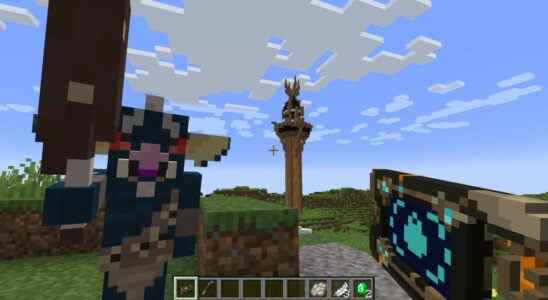 Minecraft - A player holds a modded Sheikah Slate while looking at a blue Bokoblin from Zelda, with a Sheikah tower in the background.