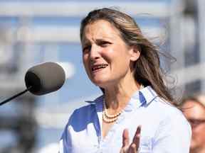 La vice-première ministre Chrystia Freeland (sur le podium) prend la parole après avoir visité une installation de production d'hydrogène exploitée par Air Products, une société de gaz industriels, avant une conférence de presse à Sherwood Park, le jeudi 25 août 2022.