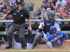 Le joueur de deuxième but des Blue Jays Whit Merrifield (1) est initialement appelé par l'arbitre Marty Foster (à gauche) à la plaque sur une étiquette du receveur des Twins Gary Sanchez lors de la 10e manche au Target Field à Minneapolis, le dimanche 7 août 2022. L'appel a été défié par les Blue Jays et renversé, jugeant Merrifield en toute sécurité sur le jeu en raison du blocage du receveur au marbre.