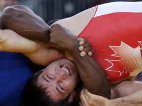 Khetag Pliev du Canada (en rouge) et Javier Cortina Lacerra de Cuba (en bleu) s'affrontent lors de leur match de lutte libre des 66 kg aux Jeux olympiques d'été de 2012, le dimanche 12 août 2012, à Londres.