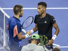 Borna Coric, à gauche, de Croatie, serre la main de Felix Auger-Aliassime, du Canada, après leur match au tournoi de tennis Western & Southern Open le vendredi 19 août 2022, à Mason, Ohio.