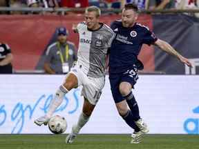 Frederico Bernardeschi (à gauche) du Toronto FC et Thomas McNamara du New England Revolution se disputent le ballon au cours de la première mi-temps samedi soir à Foxborough, Mass.