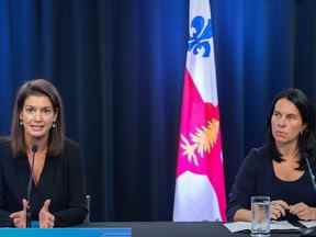 La mairesse de Montréal, Valérie Plante, à droite, regarde la ministre de la Sécurité publique du Québec, Geneviève Guilbault, prendre la parole lors d'une conférence de presse à Montréal, le samedi 27 août 2022, où elle a présenté des plans pour lutter contre la violence armée à Montréal.