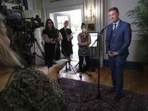 Jeremy Cockrill, à droite, ministre responsable de l'Agence de sécurité de l'eau de la province, prend la parole lors d'une conférence de presse à la Maison du gouvernement à Regina le 31 mai 2022. Le gouvernement du Parti de la Saskatchewan dit qu'il veut une explication d'Ottawa après que des employés fédéraux auraient prélevé des échantillons d'eau des agriculteurs ' atterrit sans autorisation.