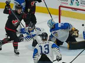 Joshua Roy (9) d'Équipe Canada marque sur le gardien de but de l'équipe de Finlande Juha Jatkola lors de la première période d'action finale pour la médaille d'or au Championnat mondial junior 2022 de la Fédération internationale de hockey sur glace à Edmonton, Canada, le samedi 20 août 2022.