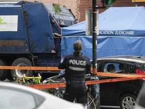 Un policier de Montréal sur les lieux d'une mort suspecte, après la découverte d'un corps dans un camion à ordures faisant sa ronde sur la rue Adam le lundi 8 août 2022.